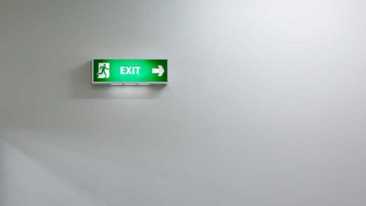 shutterstock 234875881 green fire exit sign against an indistinct soft white background