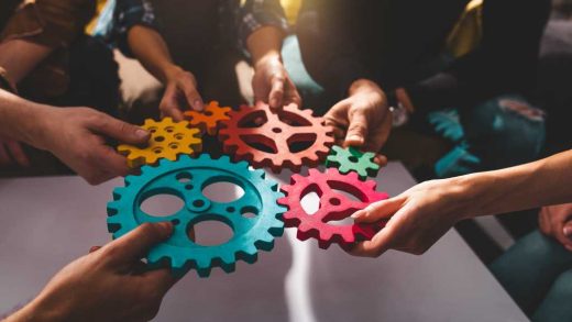 shutterstock 2270669753 teamwork concept team putting colored gears together