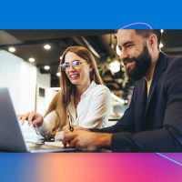 A man and woman looking at a laptop