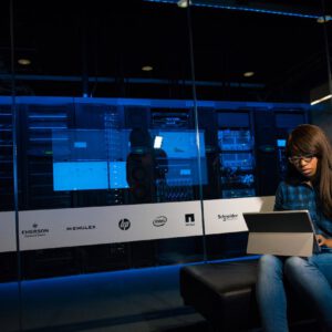 Black woman using computer in server room