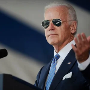 Joe biden speaking with sunglasses podium