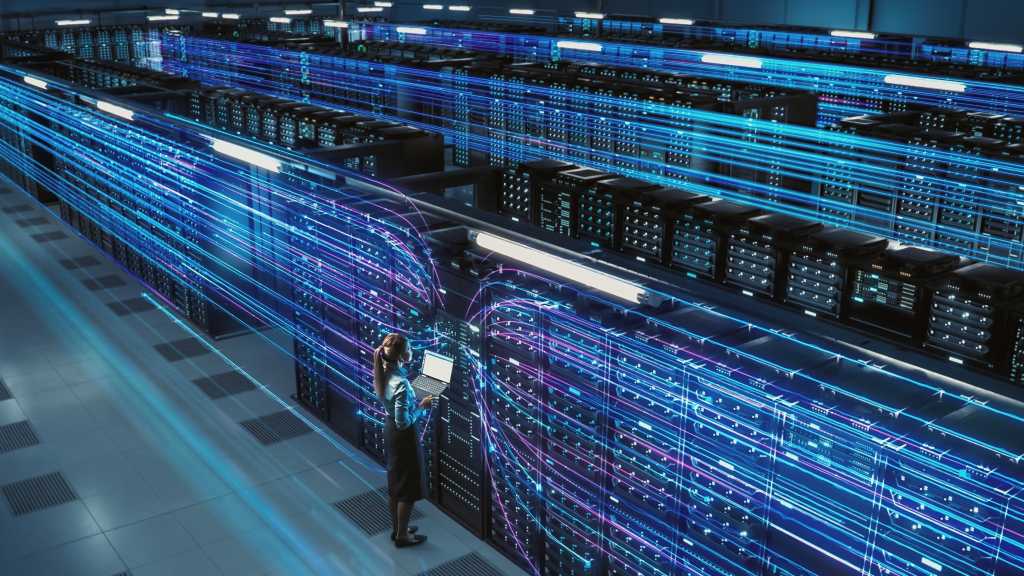 big data center female tech using laptop in data warehouse